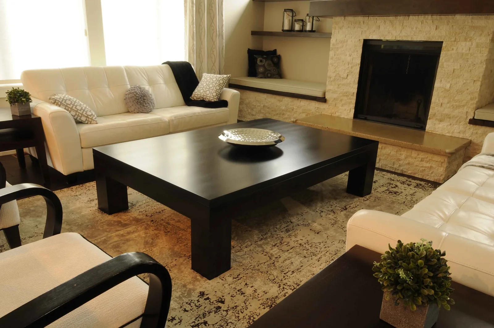 Large dark coffee table in a living room with cream sofas