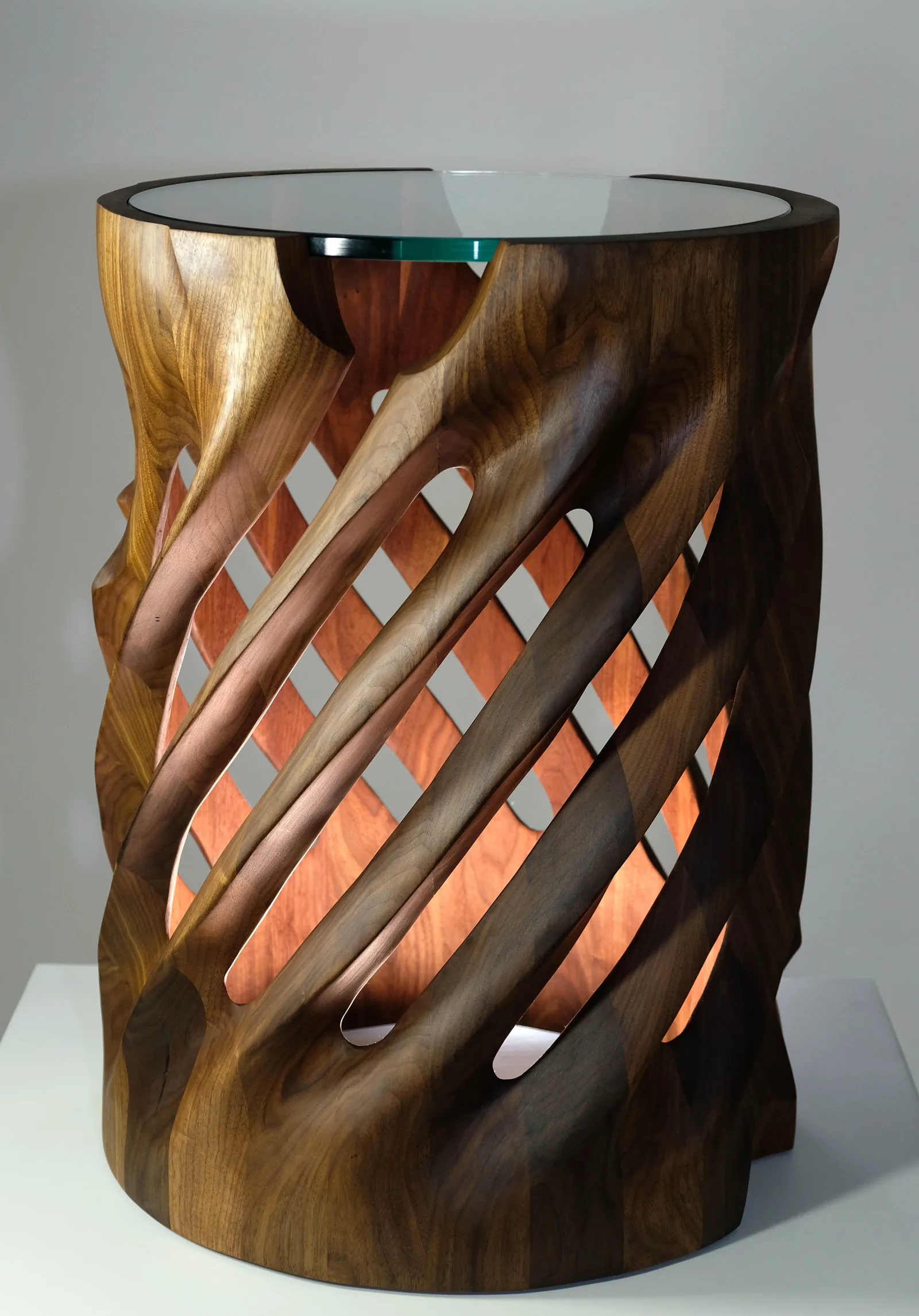 Sculpted walnut side table with spiralling slats and a glass top